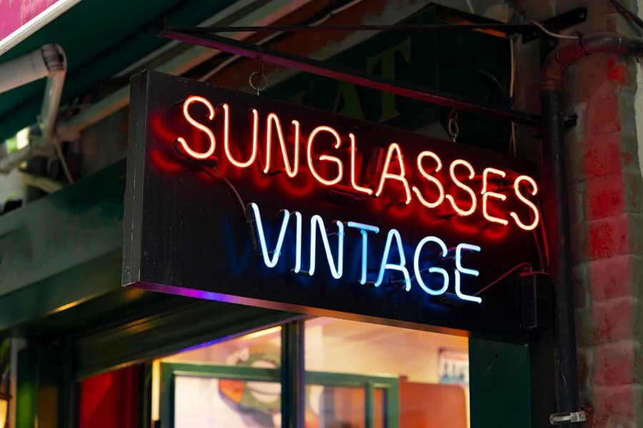 A neon sunglasses vintage signboard on a building.